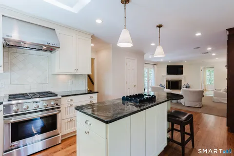 a kitchen with a stove a sink and chairs