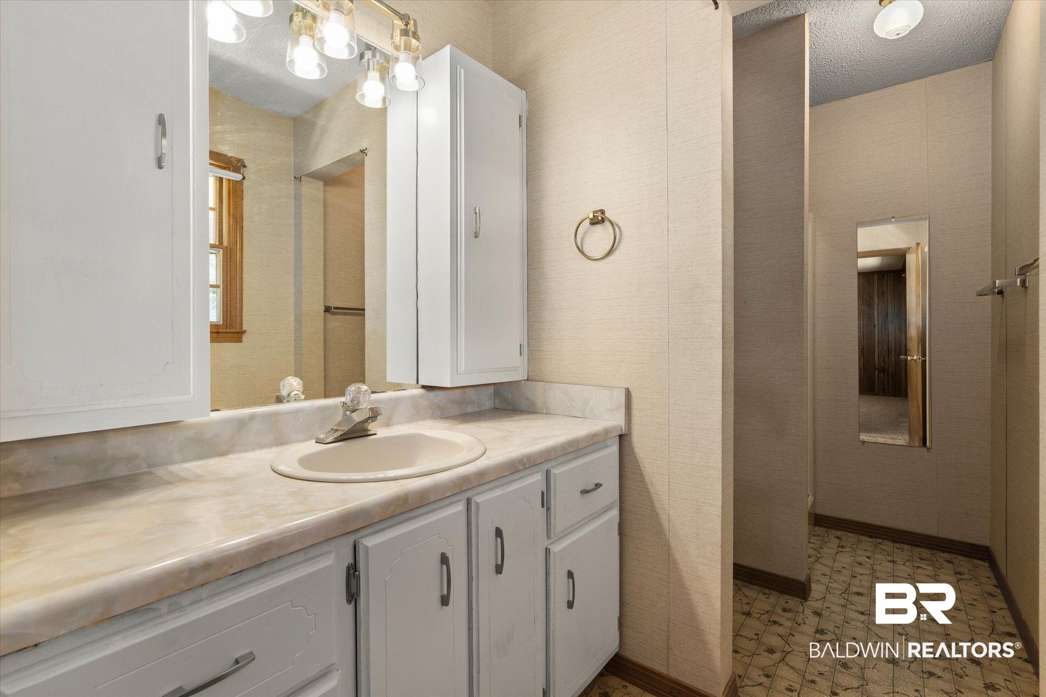 5503 Darring Street Satsuma, AL 36572 - Photo 16 of 31 Bathroom featuring vanity, wallpapered walls, tile patterned floors, and a textured ceiling