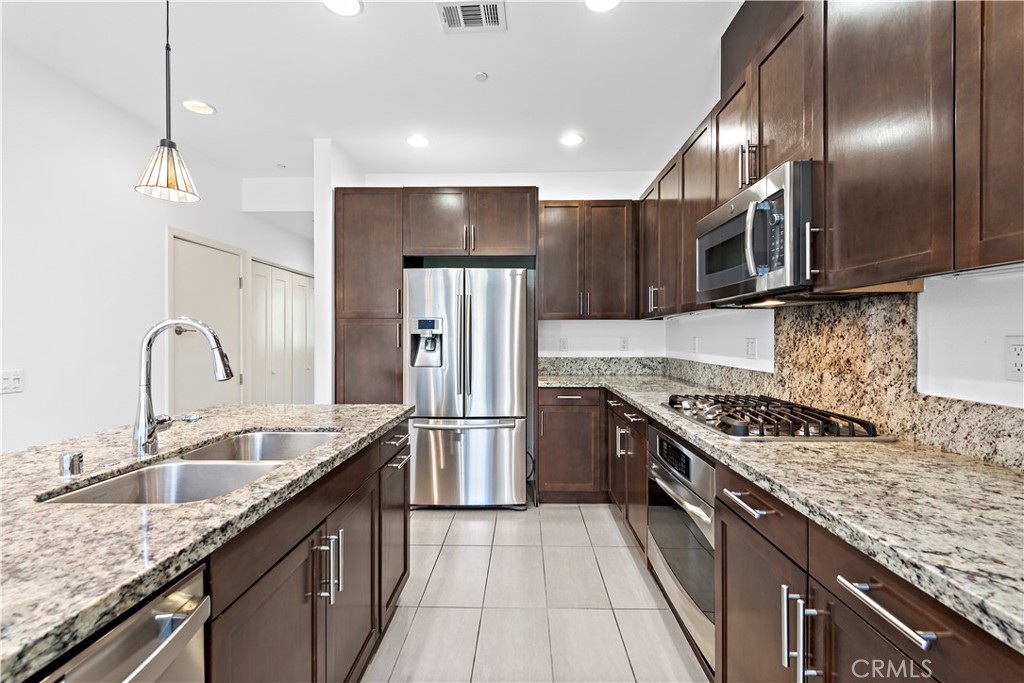 37 Soho Irvine, CA 92612 - Photo 3 of 11 a kitchen with stainless steel appliances granite countertop a sink stove and refrigerator