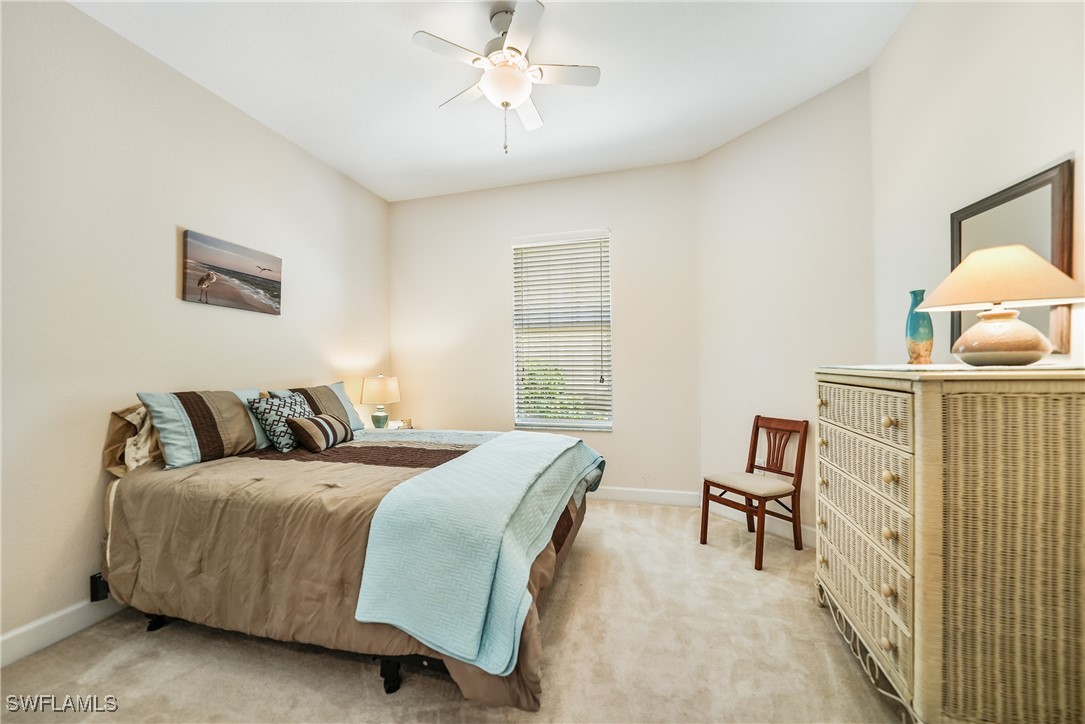 17084 Acapulco Road, Unit 211 Punta Gorda, FL 33955 - Photo 12 of 45 a bedroom with a bed a lamp and a flat screen tv