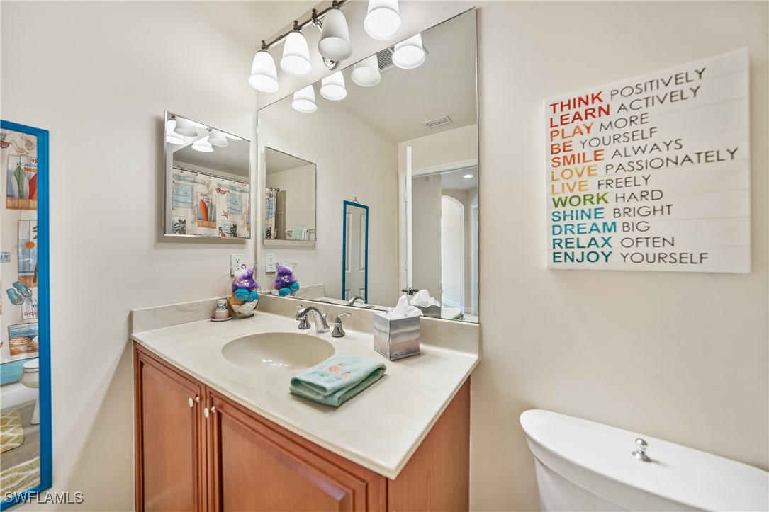17084 Acapulco Road, Unit 211 Punta Gorda, FL 33955 - Photo 14 of 45 a bathroom with a sink a toilet and a mirror