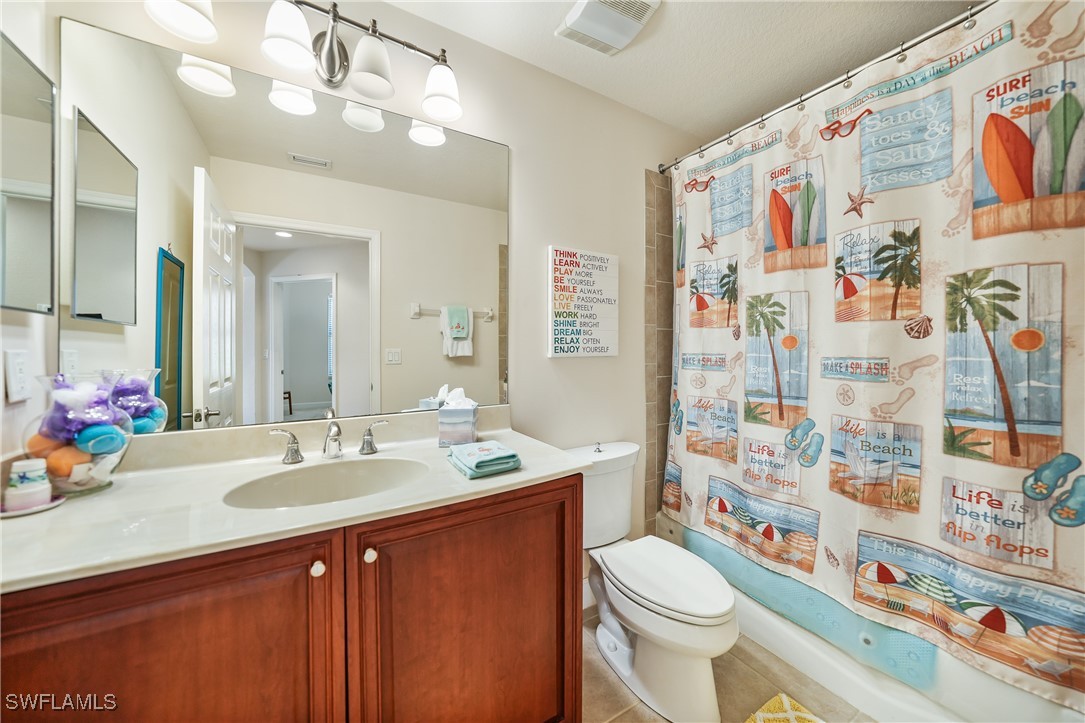 17084 Acapulco Road, Unit 211 Punta Gorda, FL 33955 - Photo 15 of 45 a bathroom with a sink a toilet and shower curtain