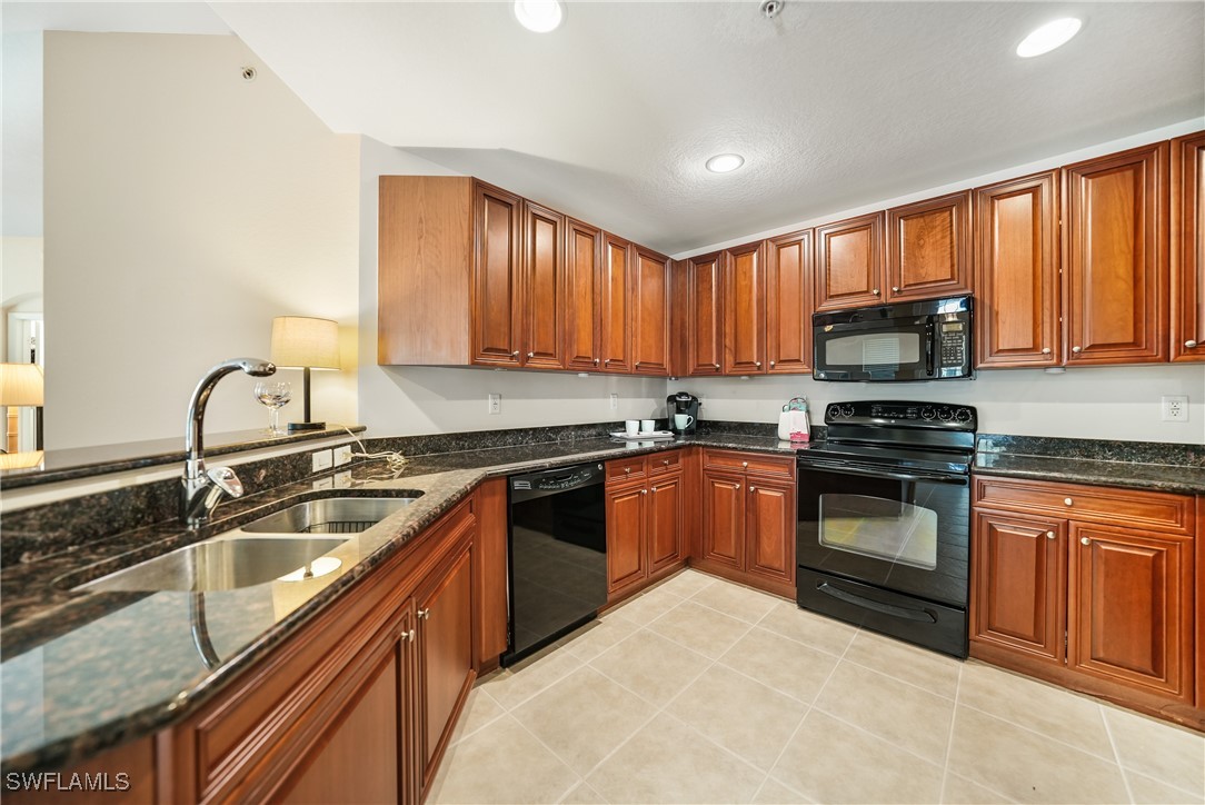 17084 Acapulco Road, Unit 211 Punta Gorda, FL 33955 - Photo 4 of 45 a kitchen with granite countertop a stove sink and microwave
