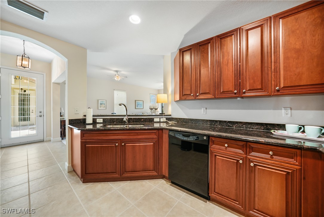 17084 Acapulco Road, Unit 211 Punta Gorda, FL 33955 - Photo 5 of 45 a kitchen with stainless steel appliances granite countertop a stove a sink and a microwave