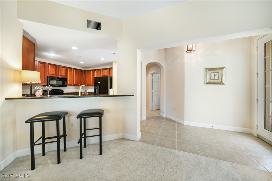 17084 Acapulco Road, Unit 211 Punta Gorda, FL 33955 - Photo 6 of 45 a kitchen with stainless steel appliances granite countertop a refrigerator and a stove top oven