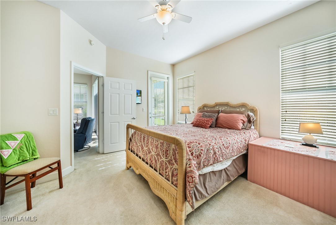 17084 Acapulco Road, Unit 211 Punta Gorda, FL 33955 - Photo 8 of 45 a bed sitting in a bedroom next to a window and a chandelier