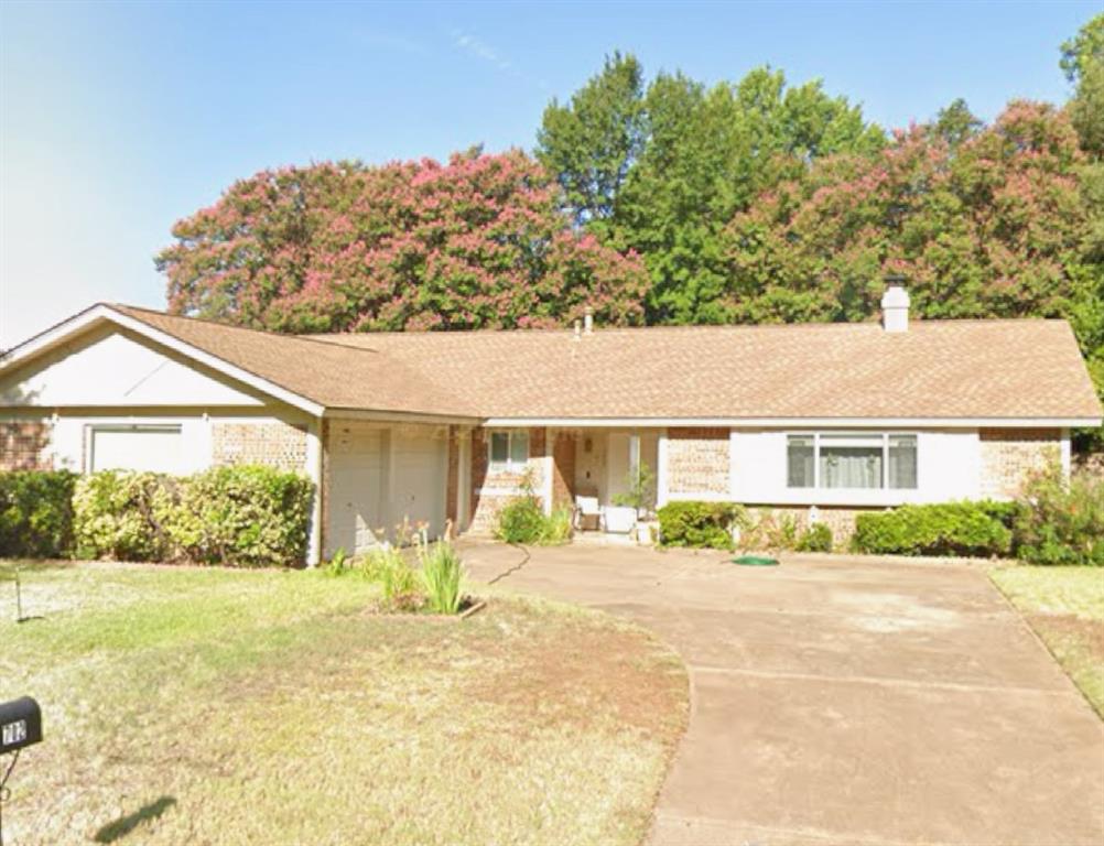 a front view of house with yard and trees in the background