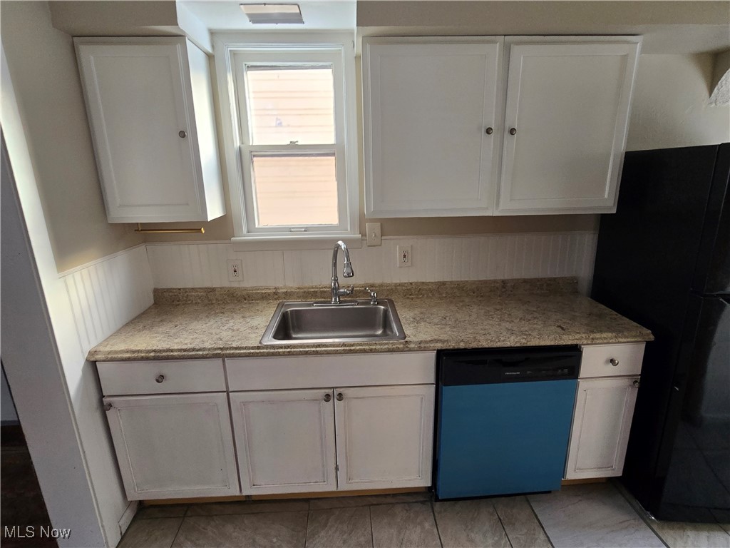 2048 Rossmoor Road Cleveland Heights, OH 44118 - Photo 7 of 29 Kitchen featuring white cabinets, dishwashing machine, light countertops, freestanding refrigerator, and a wainscoted wall