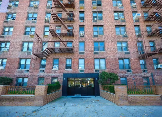 a front view of a building with a garden