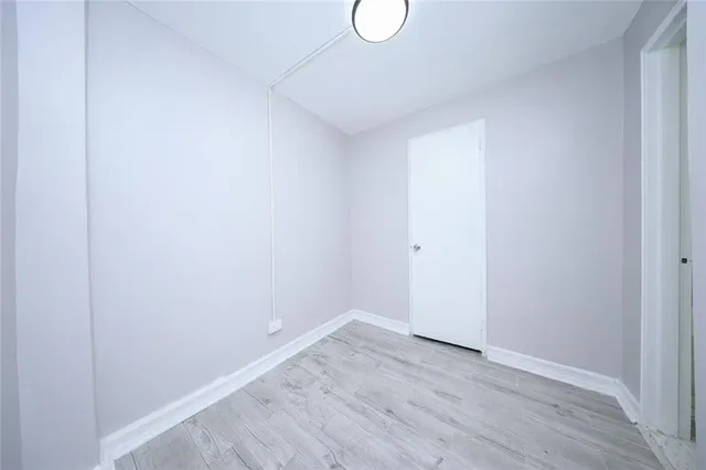 a view of a room with wooden floor and white door