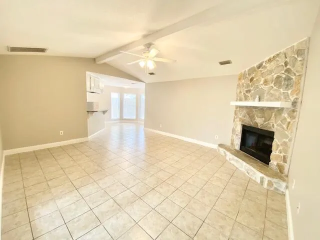 a view of empty room with wooden floor and fireplace