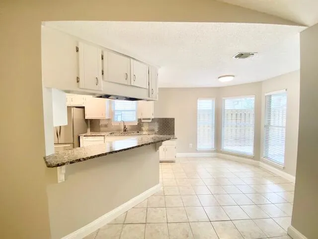 a kitchen with stainless steel appliances granite countertop a sink and cabinets