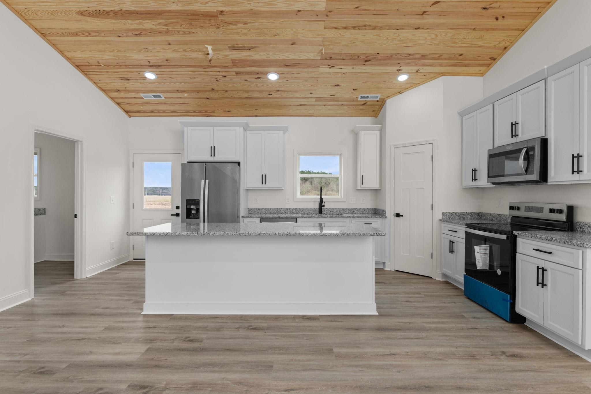 458 County Road 514 Rienzi, MS 38865 - Photo 5 of 34 a large kitchen with stainless steel appliances granite countertop a stove a sink a refrigerator and white cabinets with wooden floor