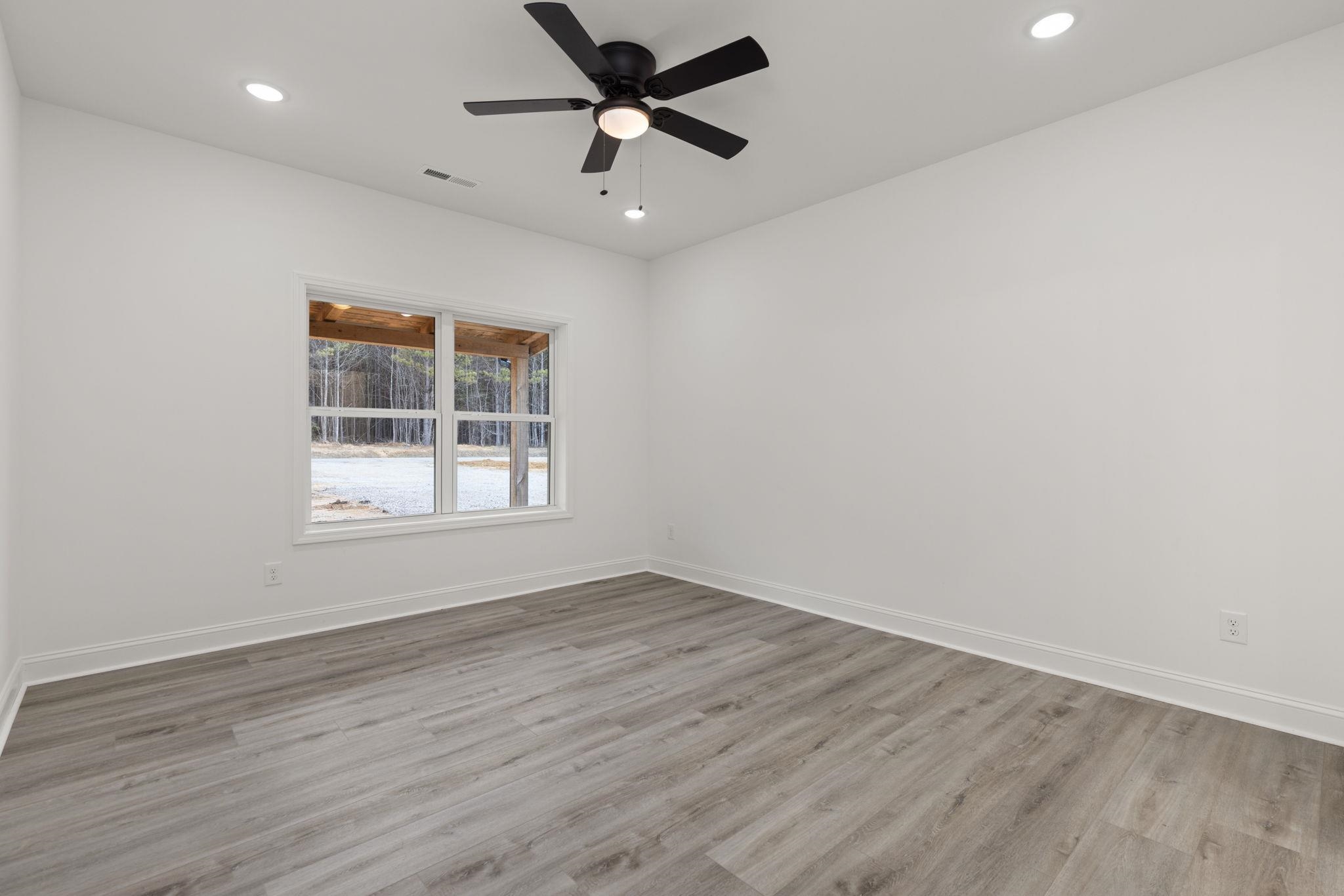 458 County Road 514 Rienzi, MS 38865 - Photo 8 of 34 an empty room with wooden floor ceiling fan and windows