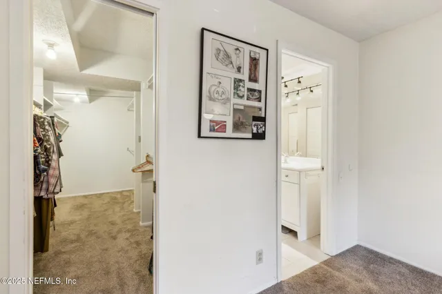 an empty room with a white walls and chandelier fan