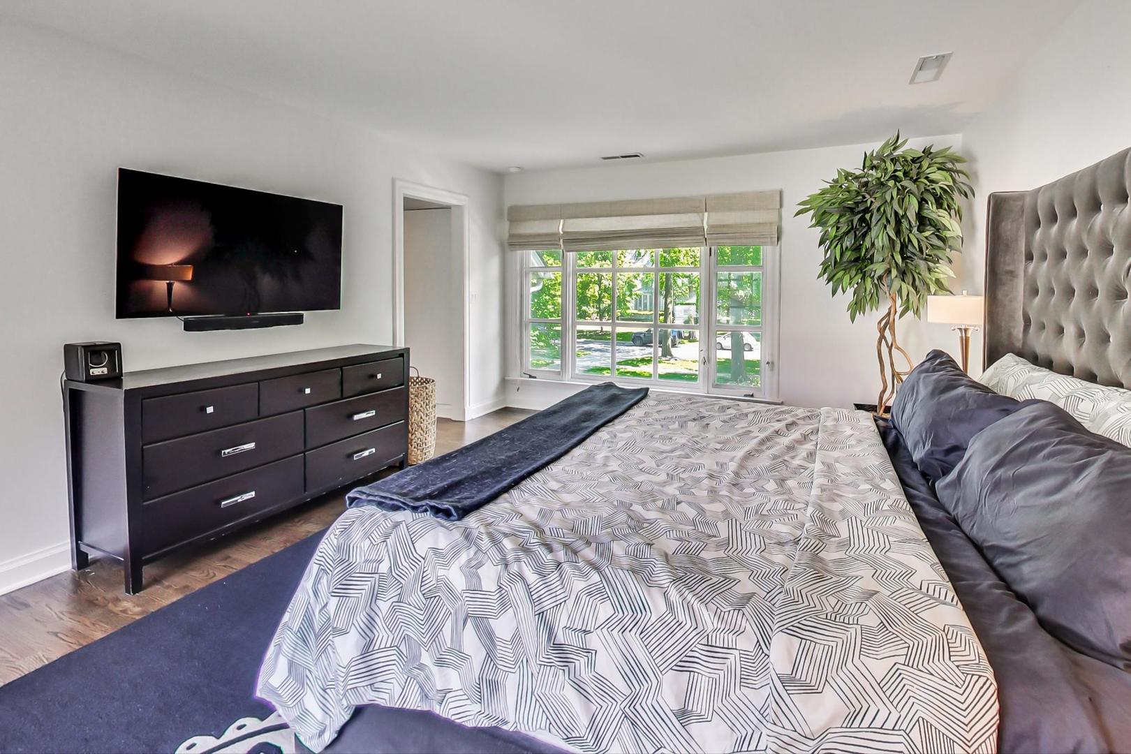 385 Washington Avenue Glencoe, IL 60022 - Photo 20 of 50 a spacious bedroom with a bed and a flat screen tv