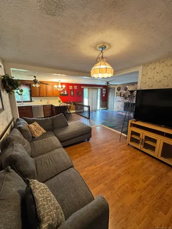 a living room with furniture a piano and a potted plant