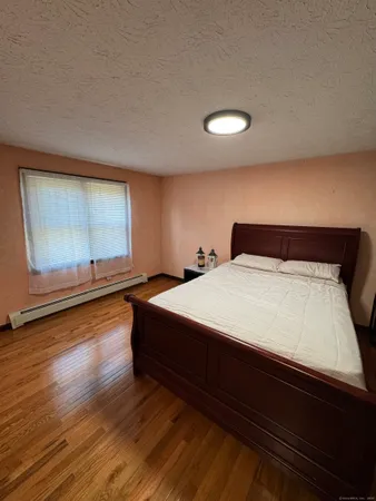 a bedroom with a bed and painting on the wall