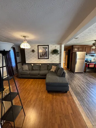 a living room with furniture a chandelier and a flat screen tv