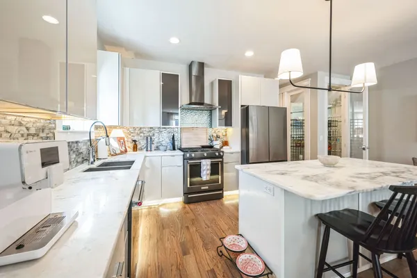 a kitchen with stainless steel appliances kitchen island granite countertop a sink stove and refrigerator