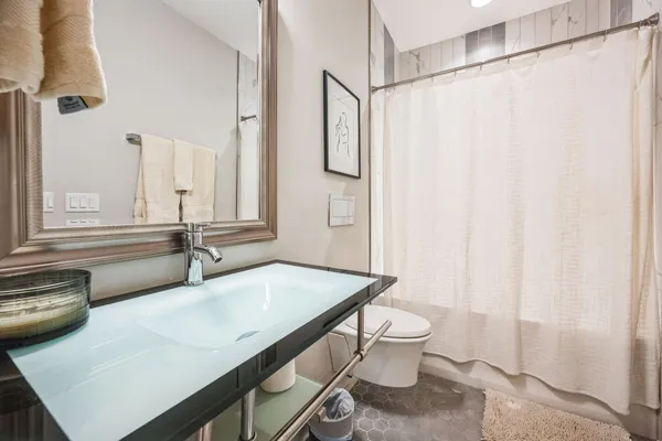 a bathroom with a sink a toilet and a mirror