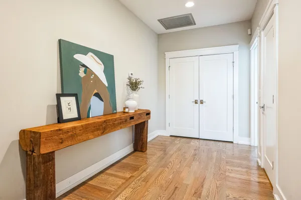 a view of a hallway with wooden floor and windows