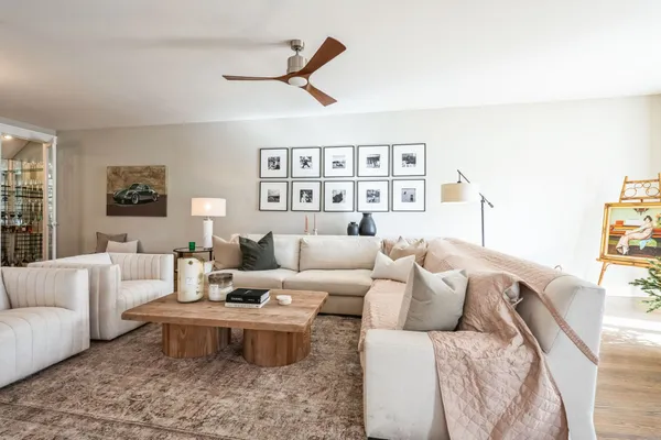 a living room with furniture ceiling fan and a window