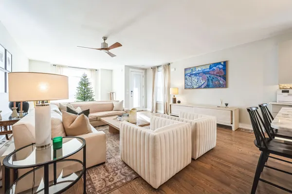 a living room with furniture a chandelier and a rug
