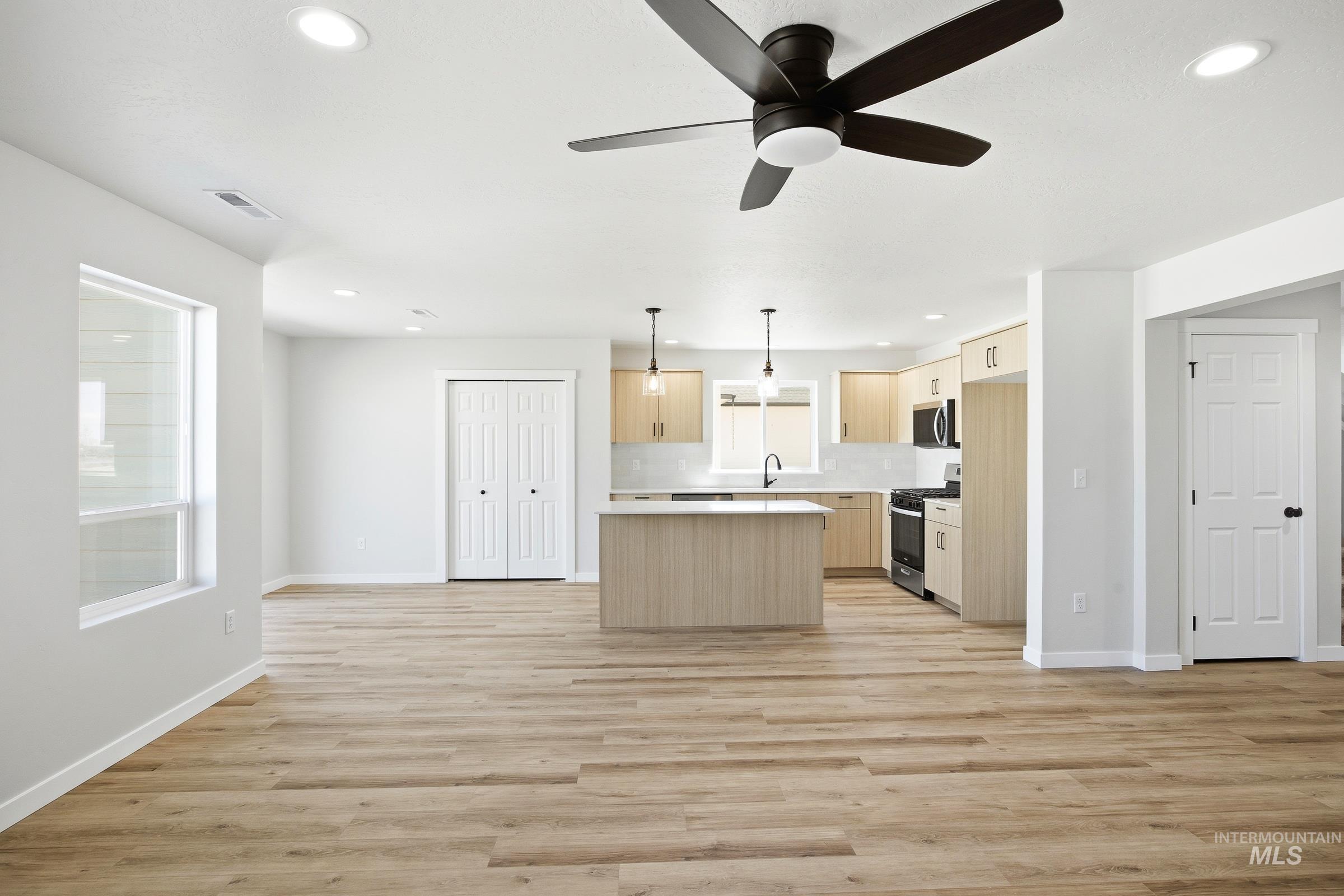 12841 Decatur Street Nampa, ID 83651 - Photo 8 of 30 Open-concept living area featuring wood-finish flooring, recessed lighting, and a contemporary ceiling fan
