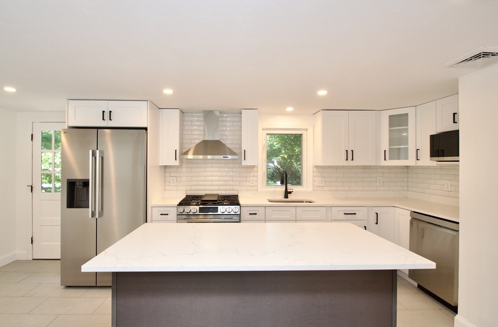 7 Barbara Road Kingston, MA 02364 - Photo 2 of 26 a kitchen with a sink a stove a refrigerator and white cabinets
