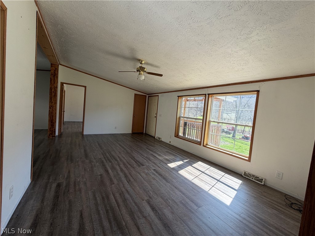 1285 Moody Hollow Road Blue Rock, OH 43720 - Photo 7 of 20 Unfurnished living room with dark wood finished floors, ornamental molding, ceiling fan, and a textured ceiling
