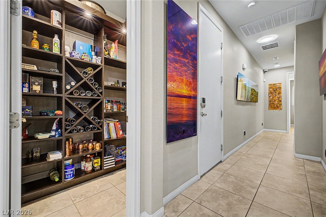 7415 Campbell Ranch Avenue Las Vegas, NV 89179 - Photo 23 of 52 Discover a well-appointed pantry with extensive storage and built-in wine racks, alongside a functional hallway.