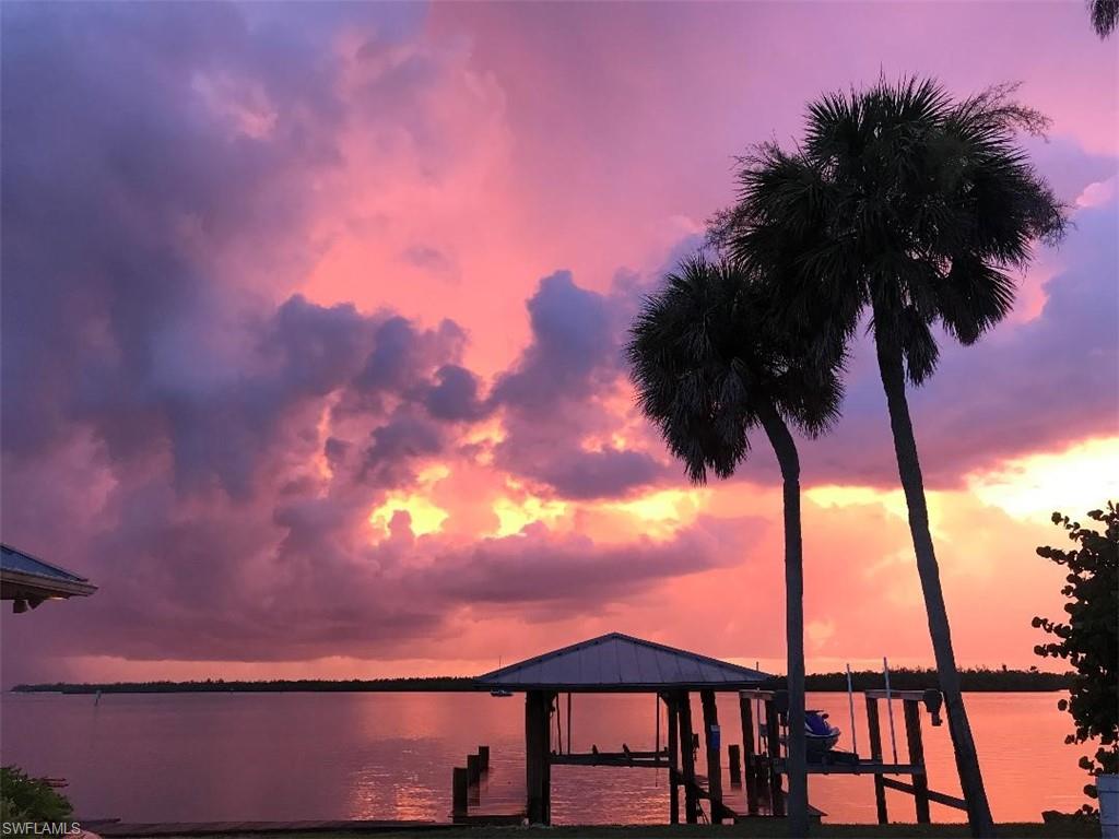 410 Cristobal Street Naples, FL 34113 - Photo 10 of 50 a view of backyard with a table and chairs under an umbrella