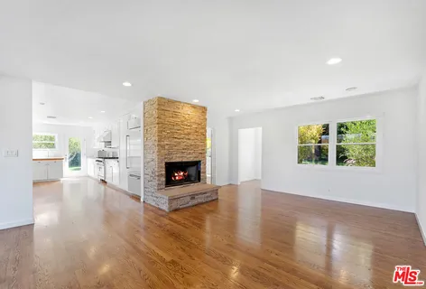 a view of an empty room with a fireplace and a window