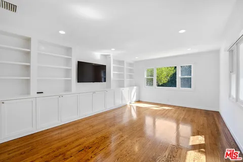 a view of a livingroom with an empty space and wooden floor