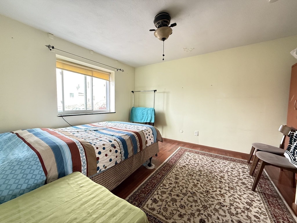 215 Washington Avenue, Unit 9 Chelsea, MA 02150 - Photo 6 of 17 a bedroom with a bed and wooden floor