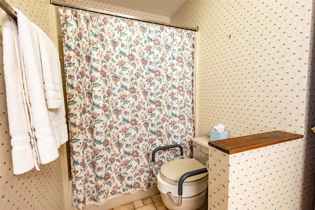 a bathroom with a toilet and a shower curtain