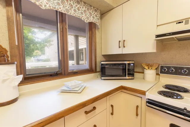 a kitchen with a stove and a white cabinets
