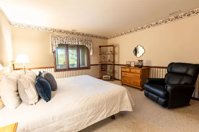 a spacious bedroom with a bed a couch and dresser