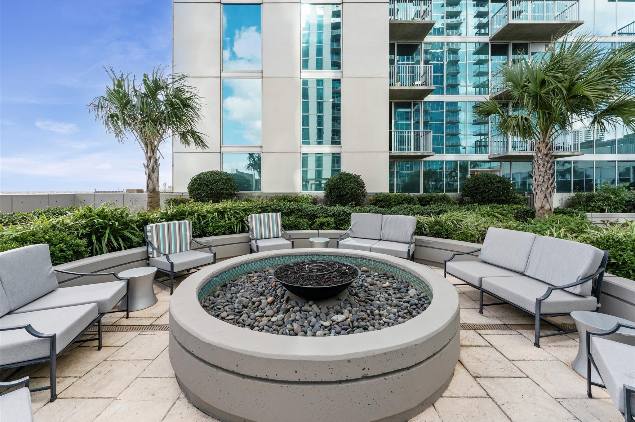 5925 Almeda Road, Unit 11315 Houston, TX 77004 - Photo 23 of 31 a view of a patio with couches table and chairs potted plants and palm tree