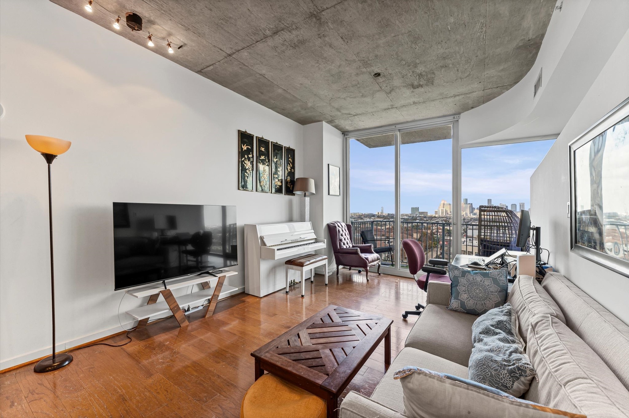 5925 Almeda Road, Unit 11315 Houston, TX 77004 - Photo 7 of 31 a living room with furniture a flat screen tv and a floor to ceiling window