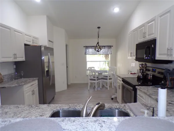 a kitchen with stainless steel appliances granite countertop a sink a stove and a refrigerator