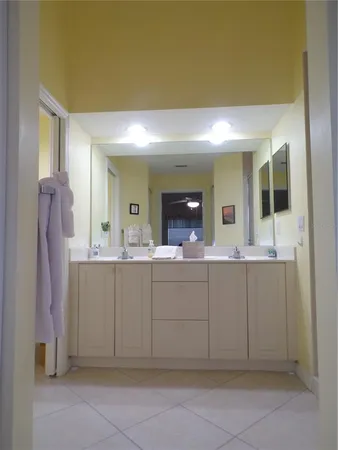 a spacious bathroom with a mirror sink and cabinets