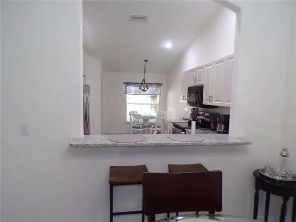 a kitchen with kitchen island white cabinets and chairs