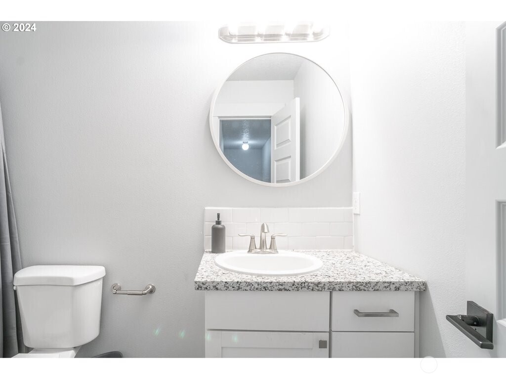 213 Oak Street Winlock, WA 98596 - Photo 20 of 32 a bathroom with a granite countertop sink and a mirror