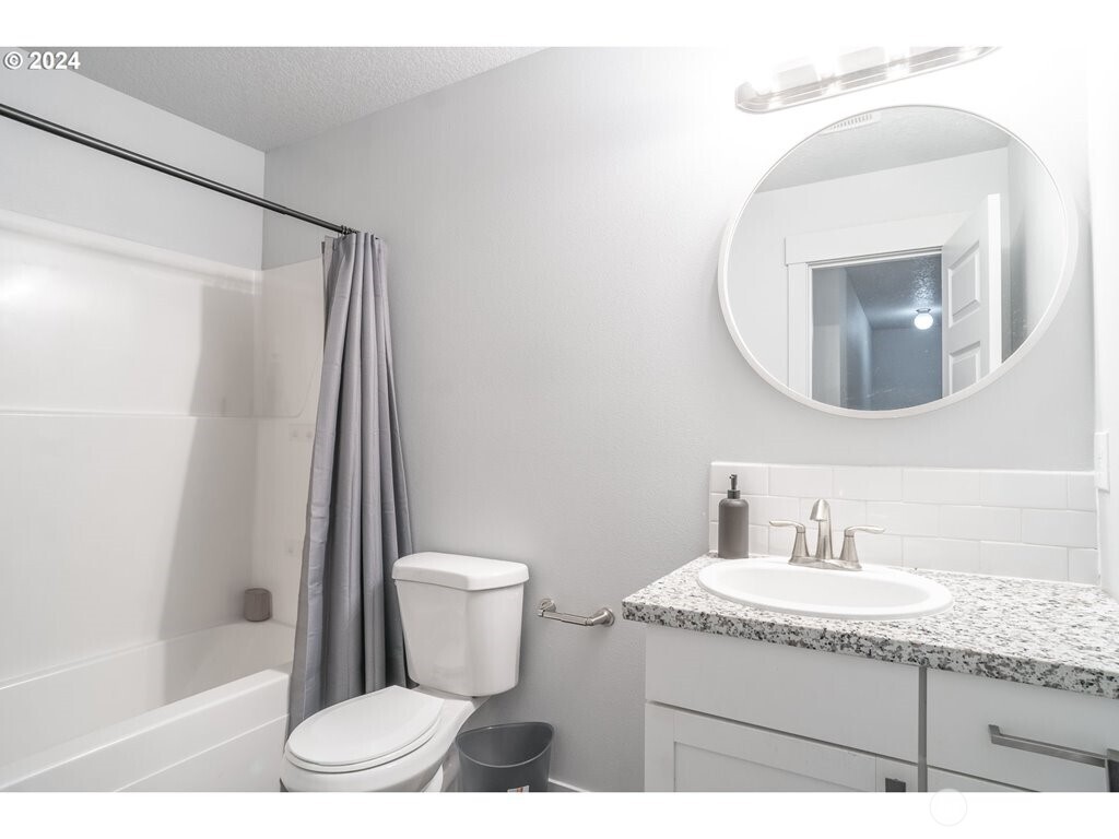 213 Oak Street Winlock, WA 98596 - Photo 21 of 32 a bathroom with a granite countertop sink a mirror and a toilet