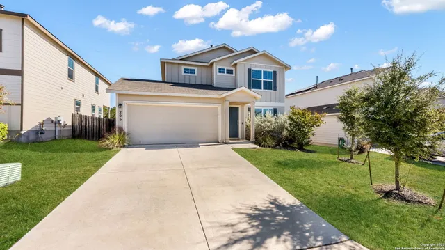 a front view of a house with a yard and trees