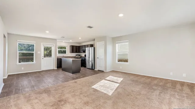 an empty room with a kitchen and windows