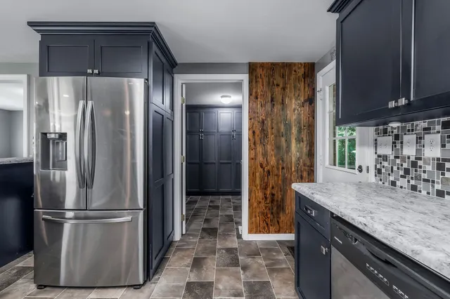 a kitchen with stainless steel appliances granite countertop a refrigerator and a sink
