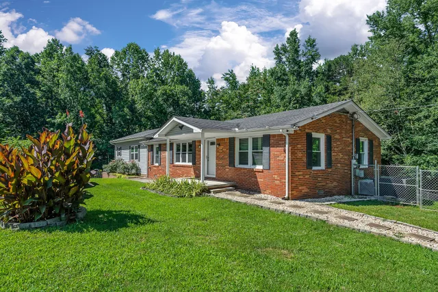 a front view of a house with a garden and yard